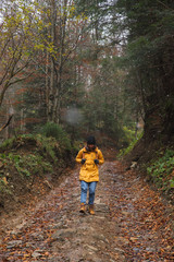 Obraz premium woman walking by path in forest autumn time hiking