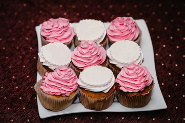 Delicious sweet muffins, cupcakes and cakes on the plate. Festive sweet table, candy bar. The concept holiday, birthday celebration.