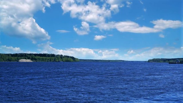 water ripples in Volga river and blue sky with flying white clouds