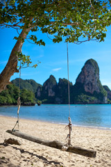 Schaukel hängend am weißen Sandstrand in Thailand, Railay Beach. Sommerurlaub mit blauem Himmel.