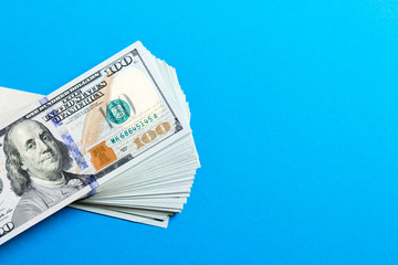 Stack of 100 dollar banknotes on colorful background. Top view of financial concept with empty...