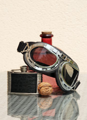 Still life with hip flask and motorcycle goggles