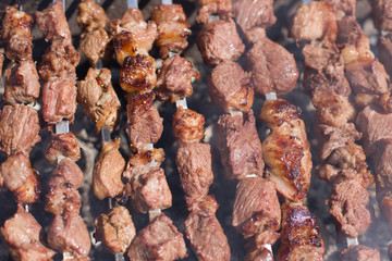 The texture of roasted meat. Appetizing cuts of meat on skewers. Grilled lamb, very tasty food. Kebab background.