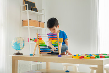A boy playing with blocks to develo brain and learning skill in playroom