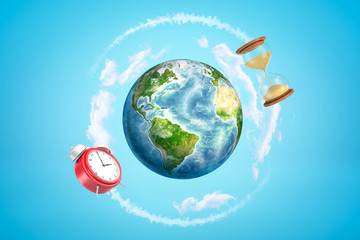 Naklejka premium 3d rendering of colored earth globe with red alarm clock and sand glass on blue sky background