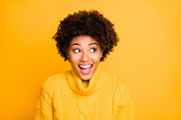 Photo of amazing dark skin lady look side to empty space on banner wear warm sweater jumper isolated yellow background