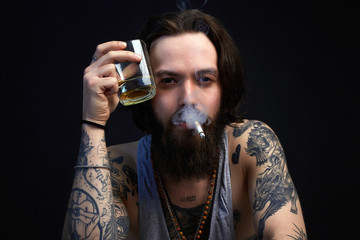 man with glass of alcohol and cigarette