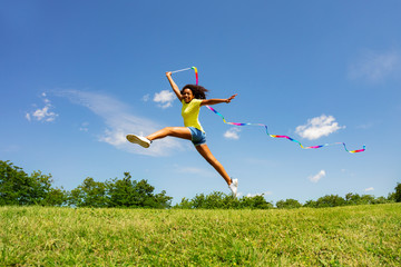 Cute girl long jump waving colorful ribbon