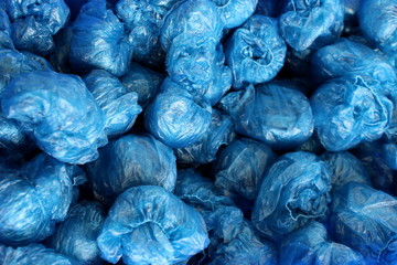 Fototapeta na wymiar in a heap are rolled up disposable blue shoe covers