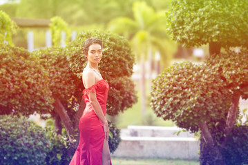 Beautiful portrait asian woman dress in red fashion evening dress act like model and look at camera.process in vintage style.