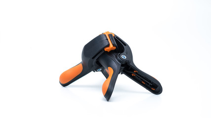 Naklejka premium Pair of black and orange color heavy duty plastic spring clamp. Holder or grip equipment for photography and woodworking tools. Isolated on white. Copy space.