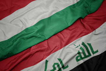 waving colorful flag of iraq and national flag of hungary.