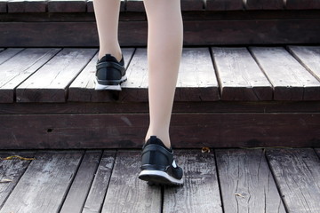 female legs climb the wooden stairs