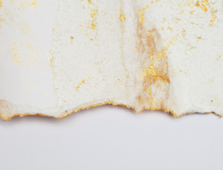 Torn piece of edge paper on white background. Gold and bronze color marble texture.