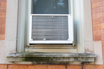 Window Air Conditioning Unit seen from Outside on a Brick Urban Building
