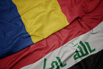 waving colorful flag of iraq and national flag of romania.