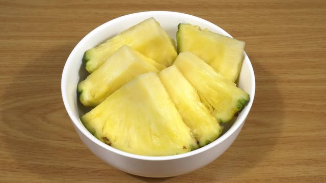 Pi&ntilde;a cortada en trozos en un bol de cer&aacute;mica