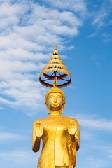 Sculpture Golden Buddha Statue standing isolated with Clearly Blue Sky Background