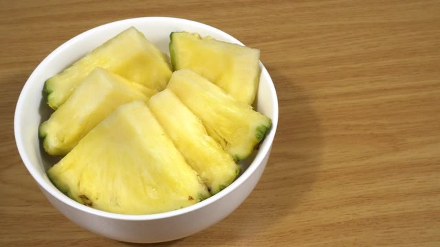 Pi&ntilde;a cortada en trozos en un bol de cer&aacute;mica