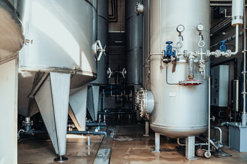 Large reservoirs and tanks and pipes in modern juice and water production plant. Industrial background
