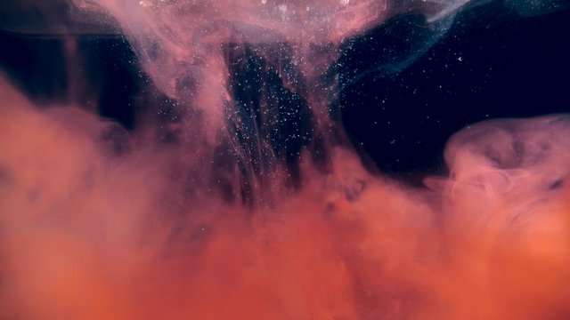 Red transparent smoke falling down making clouds of steam on a black background.