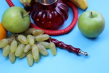 red hookah stands surrounded by fruit on a blue background