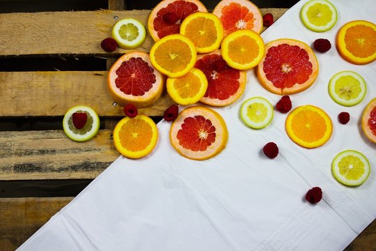 fresh sliced citrus fruits in a against a rustic background in a flat layout