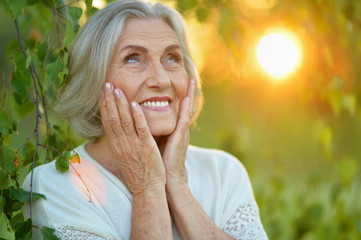 Close up portrait of happy senior woman in park