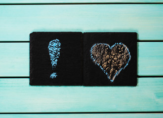 Heart and exclamation mark drawn with chalk, blue wooden background, love concept