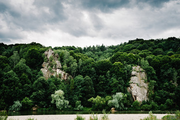 Big rock. River with rocks flows towards mountains..Mountain fast flowing river stream. Landscape with forest, river and stones. The mountain river. Place for text.