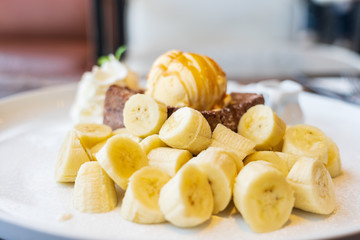 Close-up on, Honey Toast, bread buttered toast, banana, ice cream and whipped cream dessert on a white dish
