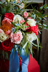 Floristic concept, business concept, gift, surprise, peonies, roses, carnations.  A large multi-colored bouquet stands on a chair. Peony, roses, carnations, eucalyptus, greens, garden flowers