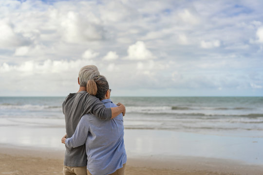 The elderly couples embraced at the seaside.The elderly couples embraced at the seaside.An old couple hugged by the sea.Mature couples relax at the seaside on holiday.