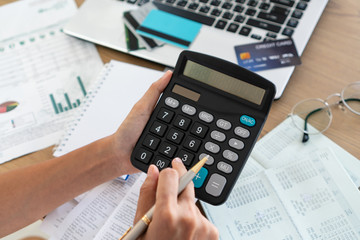 Woman holding and using calculator, account and saving concept.