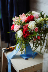 Florist girl collects a large beautiful bouquet. Floristic concept, business concept, gift, surprise, peonies, roses, carnations