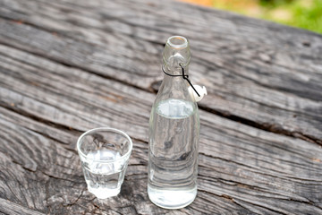 Bottle and glass with water on the wooden table