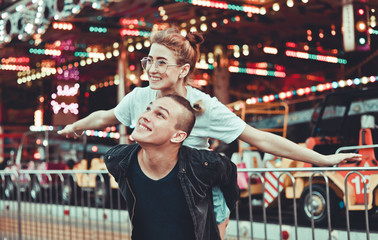 Young couple in love having fun together at amusement park Holidays, love and friendship concept