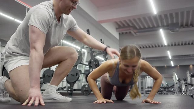 Woman doing pushups while her personal trainer is watching