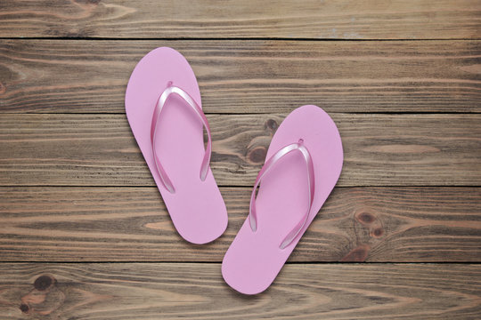 Tropical beach lifestyle. Pink Flip flops on wooden background. Summer background. Top view