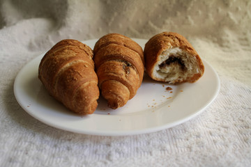 .croissants in a plate on a light background in a warm room in the morning