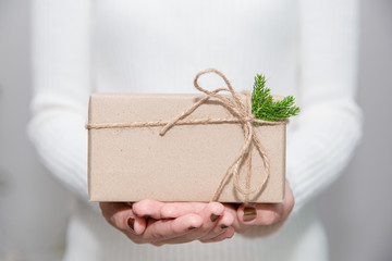 Woman hands with white sweater holding a diy gift box for special event with copy space.