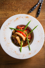 Chicken sauté. Sauteed Chicken Breast with Vegetables, garnished with scallion. Overhead, vertical