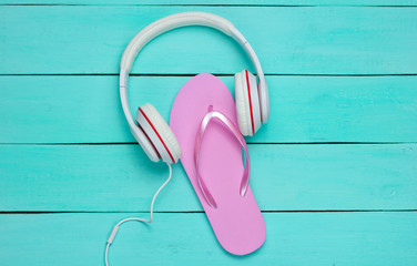 Flip flop and headphones on blue wooden background.  Summertime relax. Summer vacation. Beauty and...