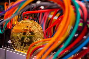 Bitcoin coin, colorful cables and printed circuit board PCB
