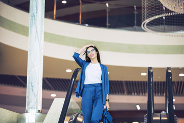 Young adult beautiful brunette girl happy businesswoman on escalator in business center