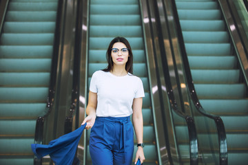 Young adult beautiful brunette girl happy businesswoman on escalator in business center