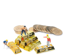 Selective focus miniature people action on golden sticks, foreman command the worker to dig the treasure.  Golden investment.
