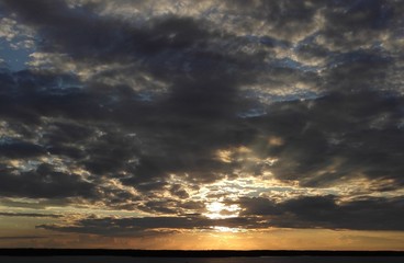 Magnificent golden sunset light beam and cumulus clouds on Baltic Sea