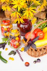 Bouquet of flowers and basket with autumn crop of seasonal vegetables