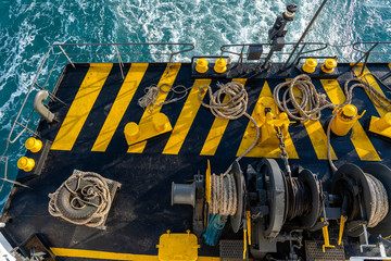 The deck of the ferry boat along with the a thick mooring rope and blue sea water wave, Thailand....